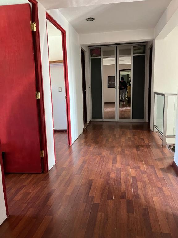 an empty room with wooden floors and glass doors at La Casa de Ikal Zacatlán in Zacatlán