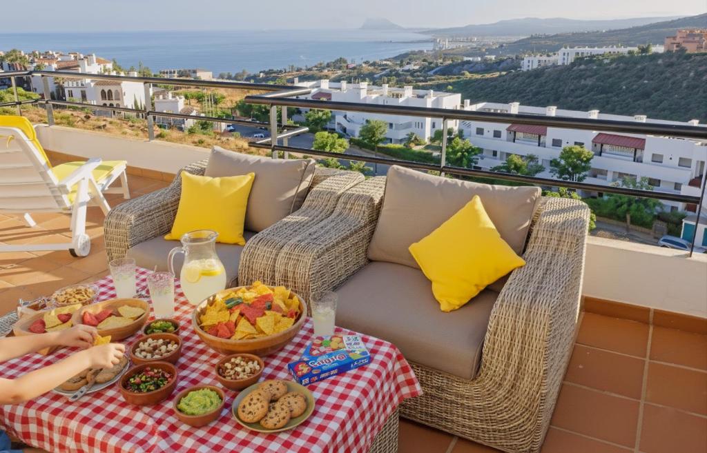 a tray of food on a table on a balcony at Blue Ark, villa vue mer avec piscine, idéale en famille face à Gibraltar in Manilva
