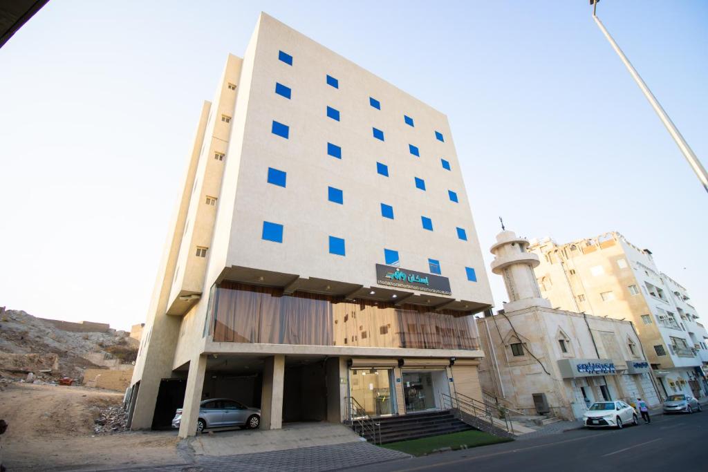 a tall building with cars parked in front of it at فندق اسكان وافر in An Naqāʼ