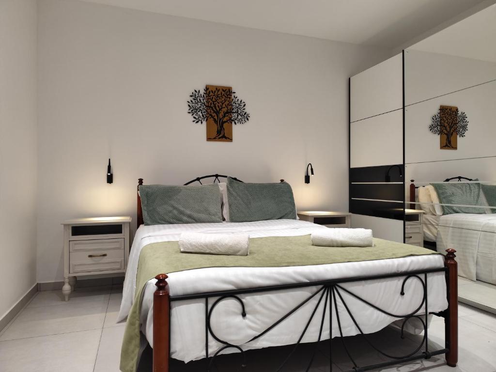 a bedroom with a large bed and a mirror at Corfu Nature Suites in Corfu