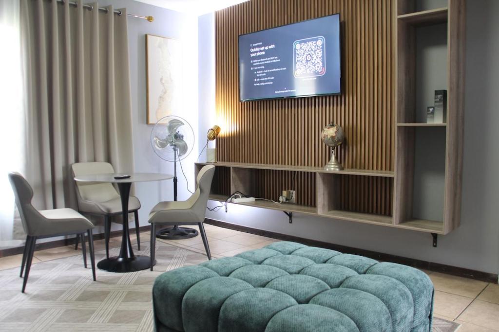 a living room with a couch and a table and a tv at Stonewall Luxury Apartment in Northriding