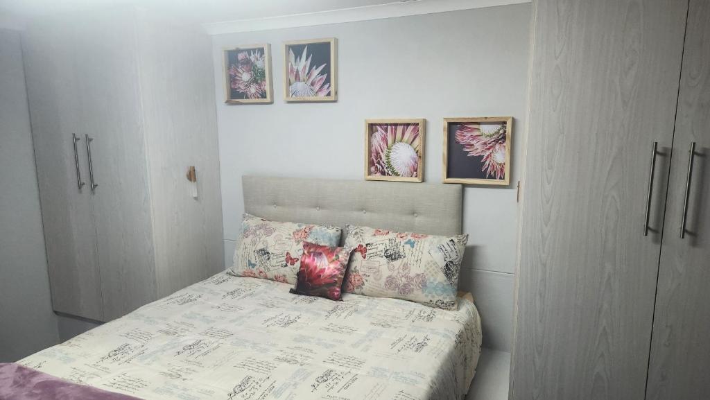 a bedroom with a bed with paintings on the wall at Sand Fontein in Springbok