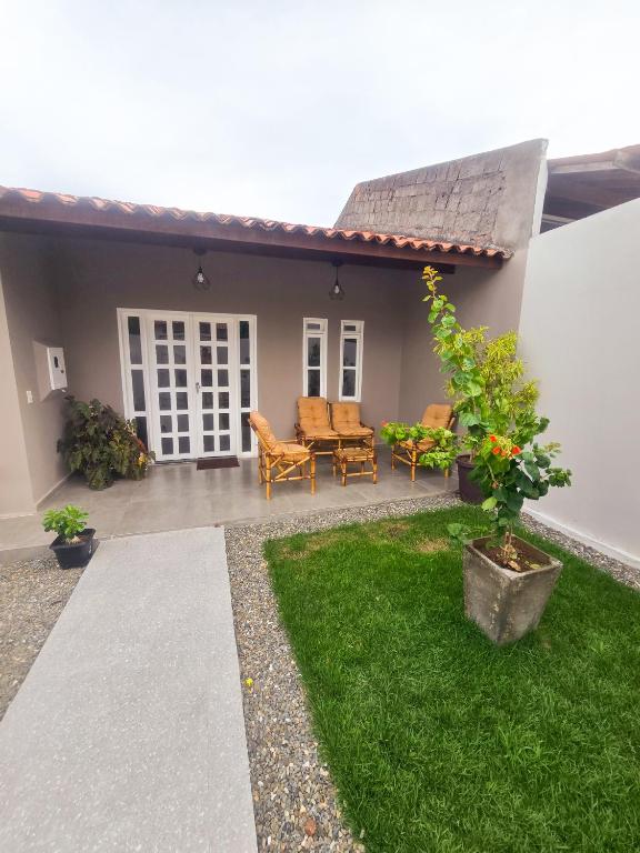 a patio with chairs and a table and a house at Casa dos Carvalhos in Piranhas