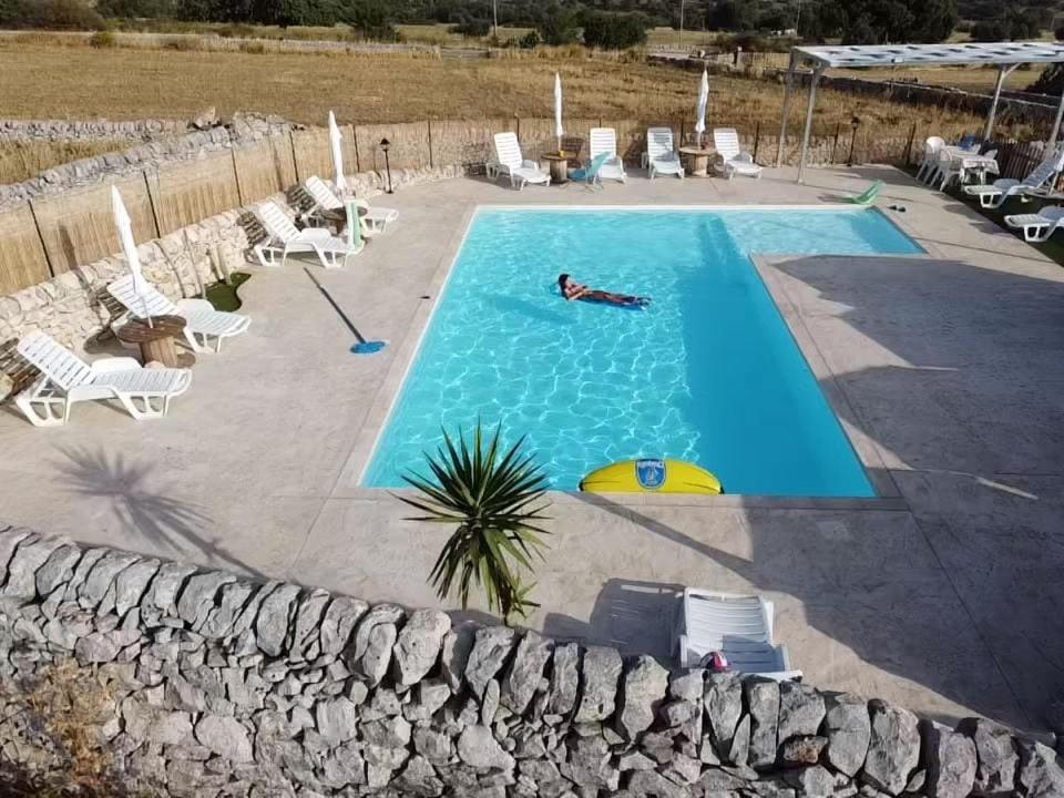 a person swimming in a large swimming pool at A Valata di Donnafugata in Ragusa
