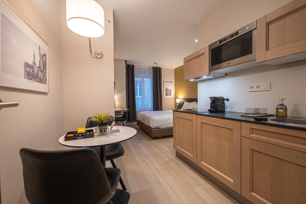 a kitchen with a table and a bed in a room at Five Resort Cholet Centre in Cholet