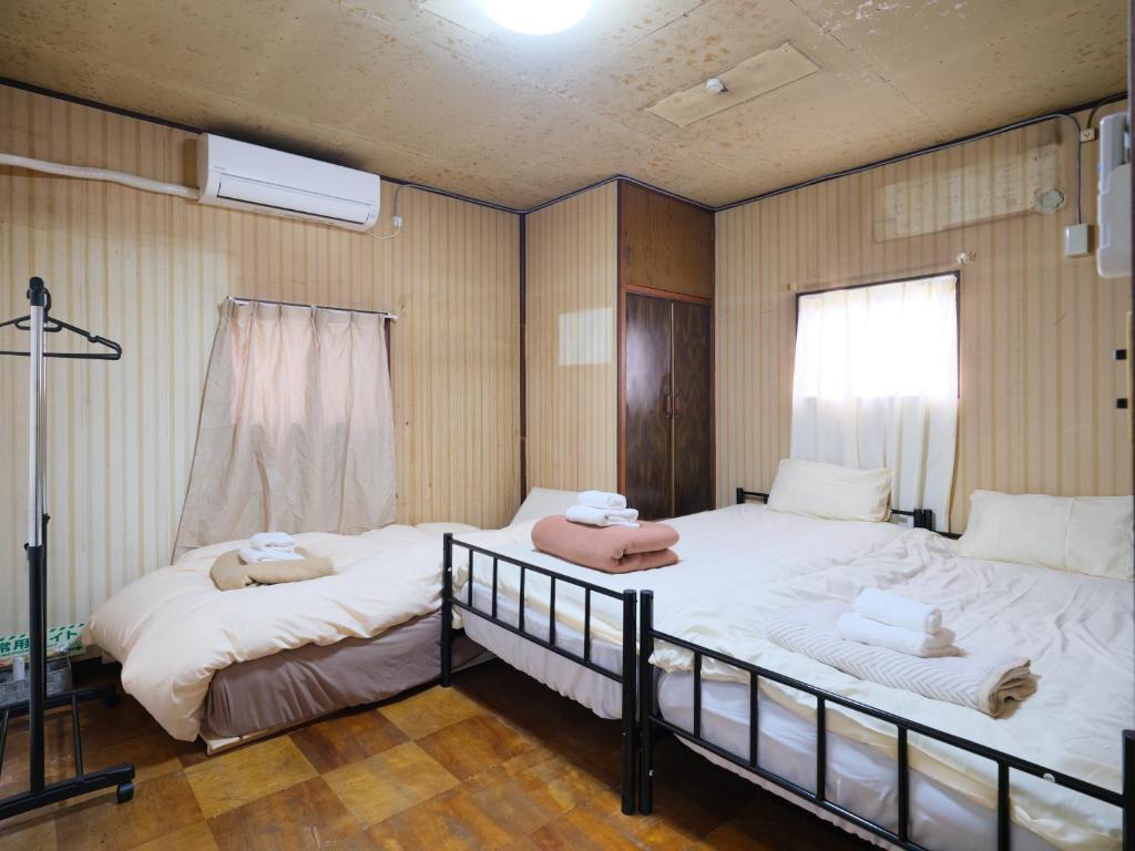 a bedroom with two beds with towels on them at Hikari-Private House in Tokyo