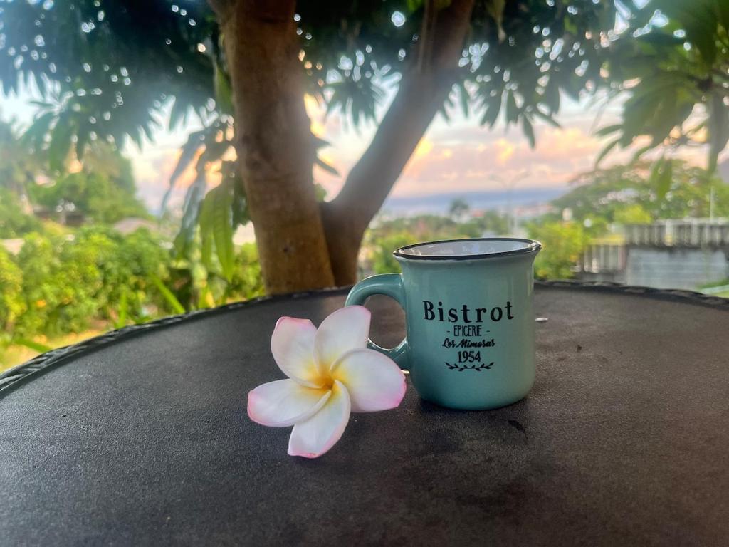a cup and a flower sitting on a table at Atea Fare Pāmata'i in Faaa