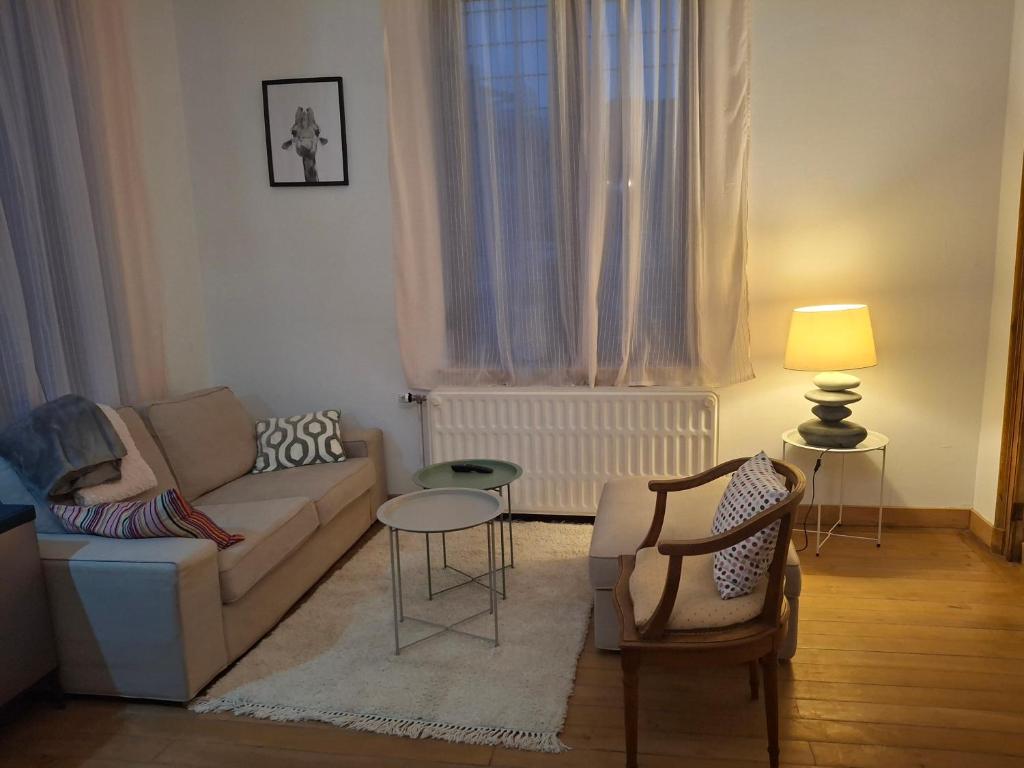 a living room with a couch and a chair at La Vie en Rose in Ensival