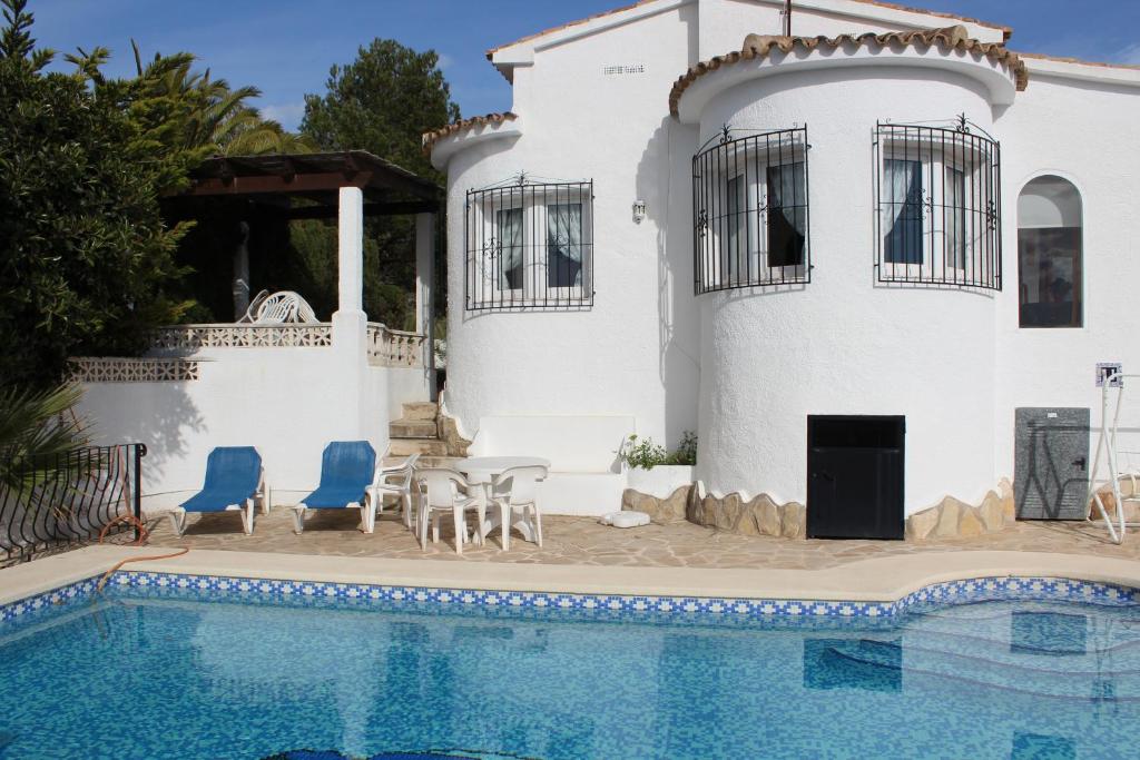 a villa with a swimming pool in front of a house at Pite in Moraira