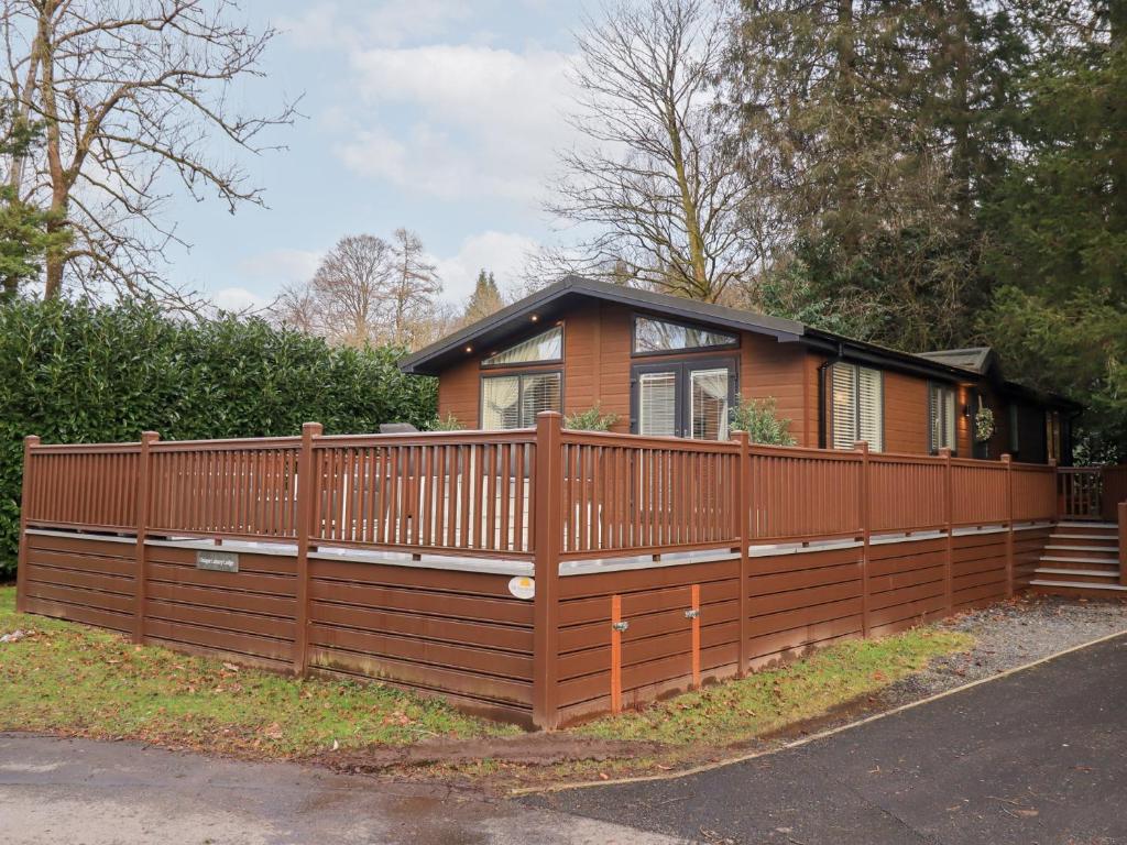 a house with a wooden fence in front of it at Unique Luxury Lodge in Windermere