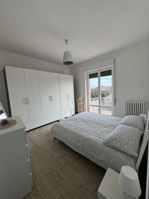 a bedroom with a bed and white cabinets and a window at Le Casette di Elfo in Grosseto