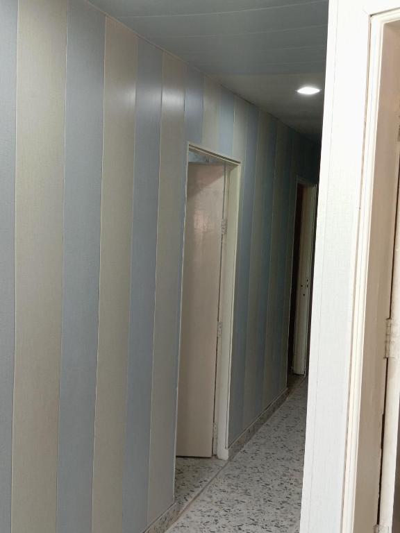 an empty hallway with blue and white striped walls at Hotel p p inn in Agra