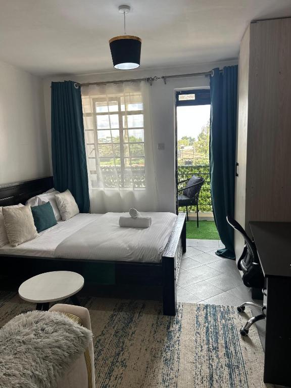a bedroom with a bed and a table and a window at JOJO Staycations in Rungiri