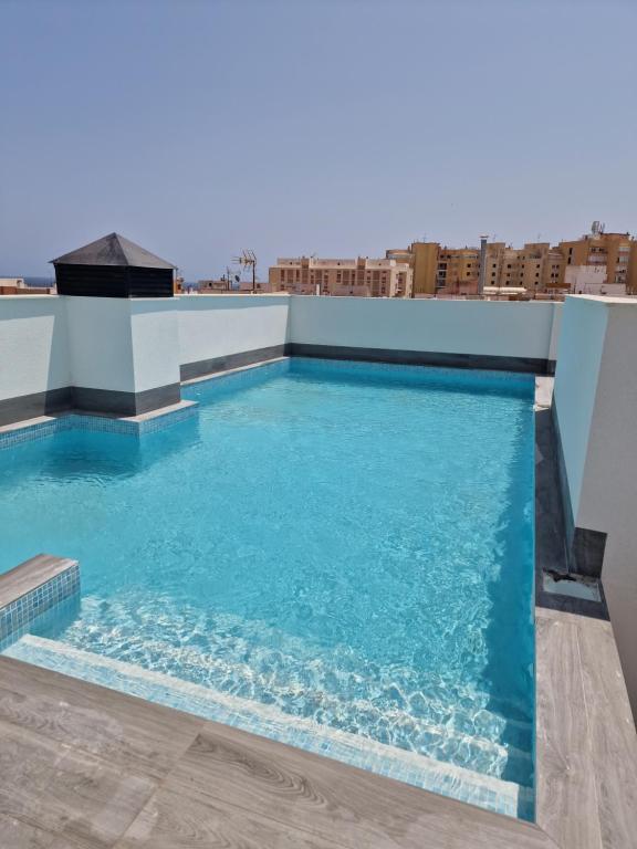 a swimming pool on the roof of a building at Lassa Holiday Apartament in Torrevieja