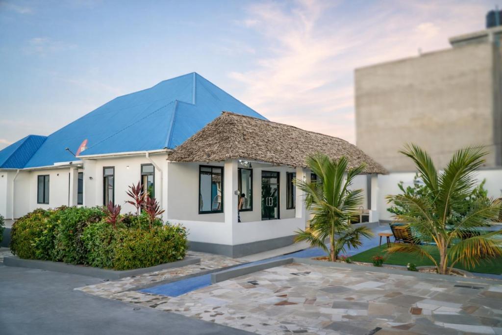 a house with a blue roof at Palm Residence Vacation Villa in Nungwi