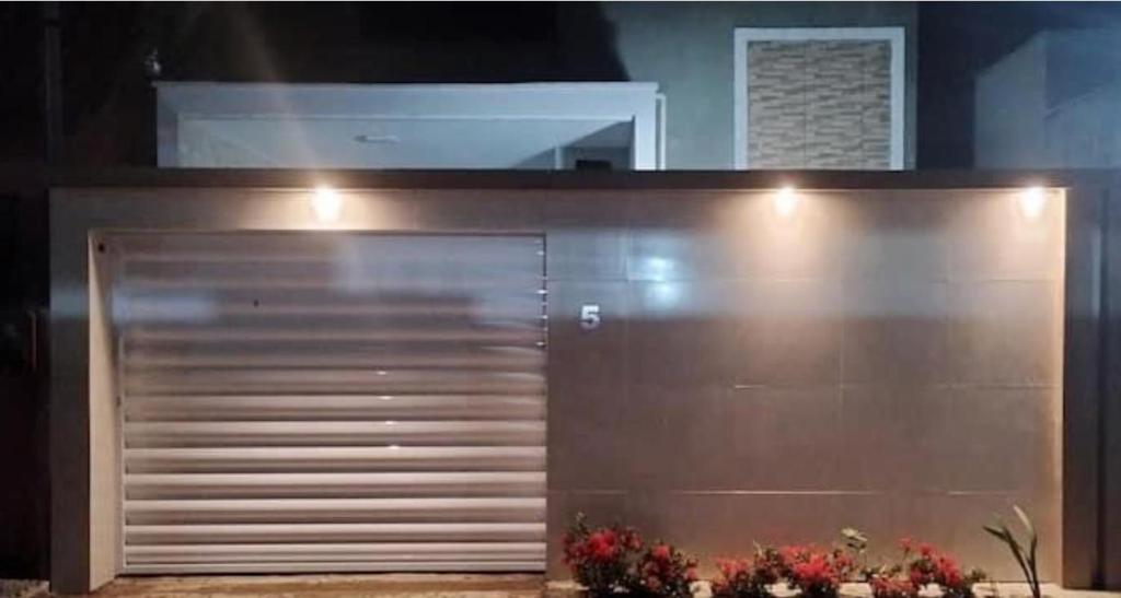 a large metal garage door in a room with flowers at Acomodações em Bananeiras, PB in Bananeiras