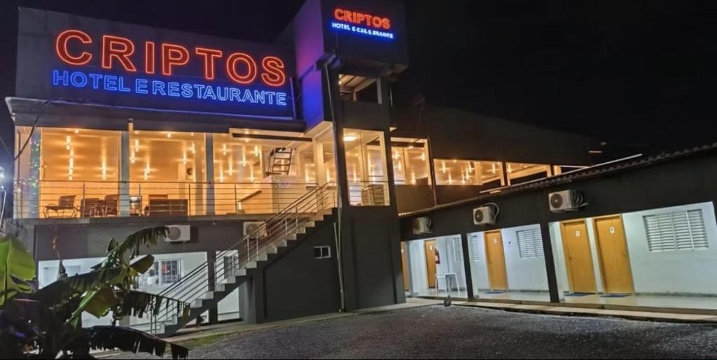 a hotel entrance with a sign on the side of a building at Criptos Hotel e Restaurante in Várzea Grande