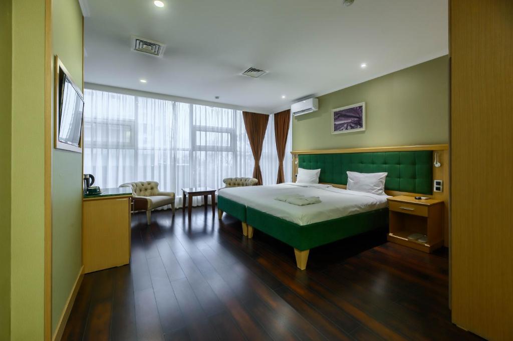 a hotel room with a bed and a table at LUVERDE HOTEL Sarkand in Almaty