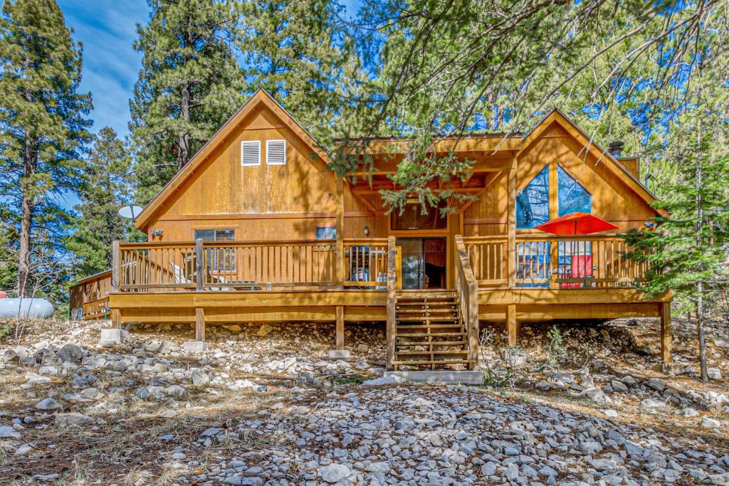 a cabin in the woods with a large deck at Peaceful & Private Cloudcroft Cabin with Deck! in Cloudcroft