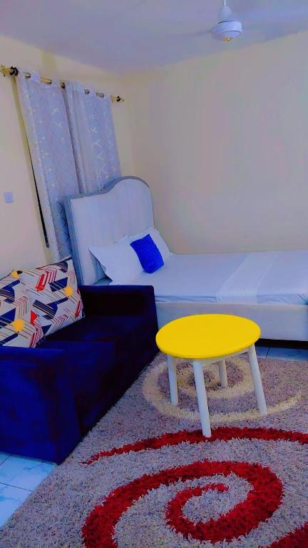 a living room with a couch and a yellow table at The Great Stay Mtwapa in Mtwapa