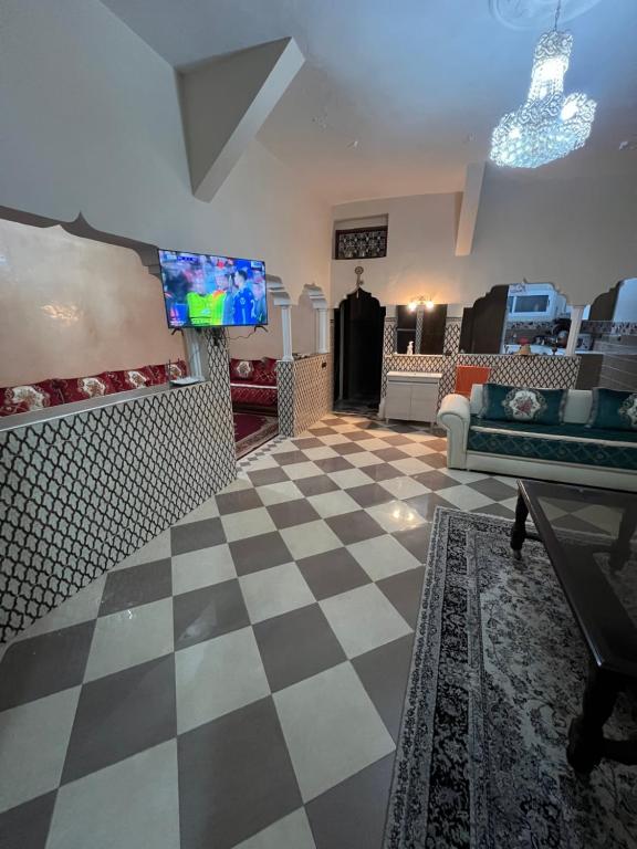a living room with a tv and a checkered floor at spacious ground floor apartment in Taroudant