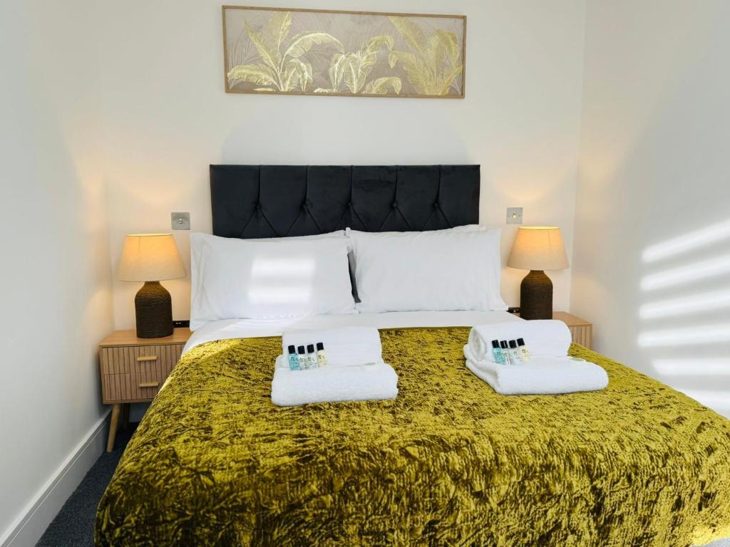 a bedroom with a large bed with two lamps at Deluxe One-Bedroom Apartment, Central in Swindon