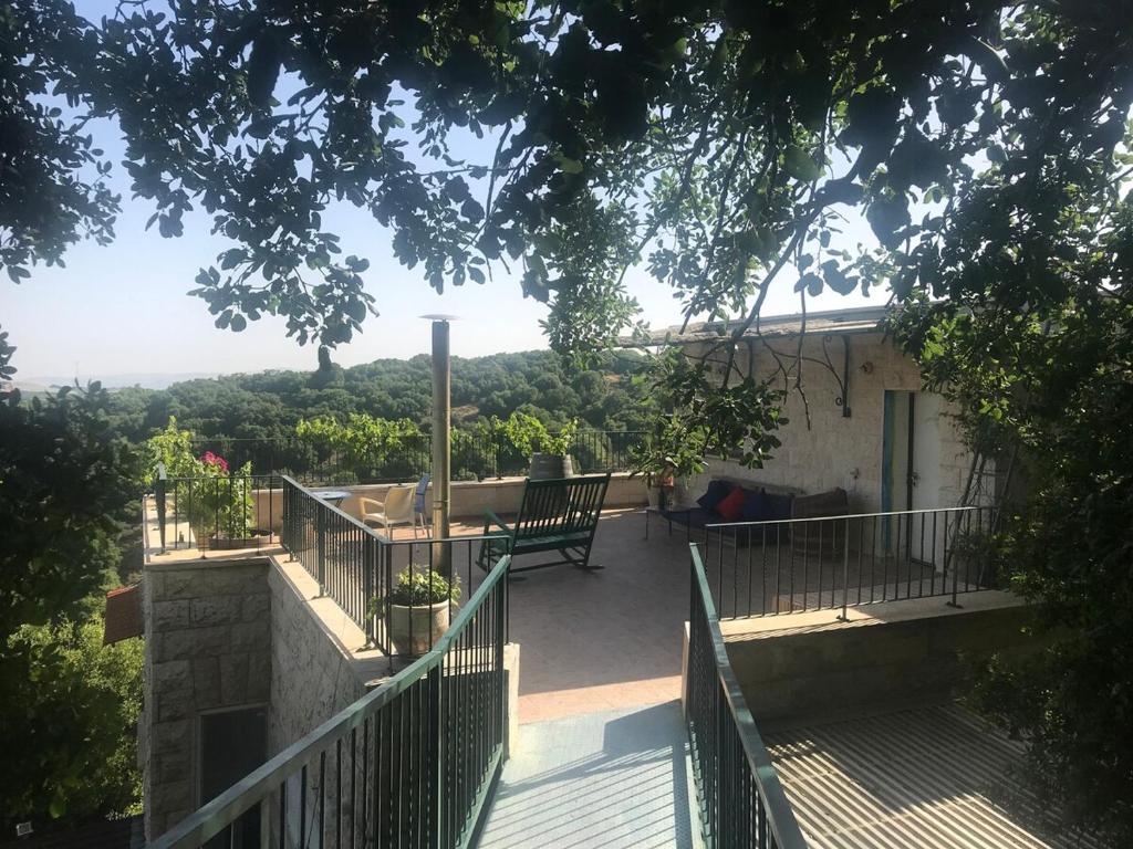 a balcony of a house with a table and benches at בשקט שלך in Mattat