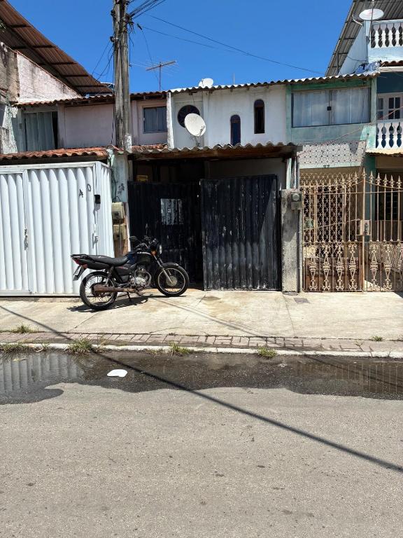 a motorcycle parked in front of a garage at Casa com 2 quartos in Cabo Frio