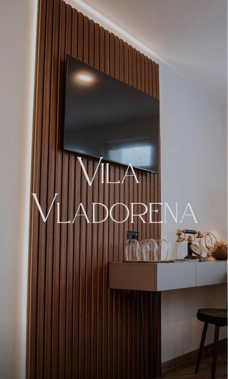 a mirror on a wooden wall with a table at Vila Vladorena in Požega