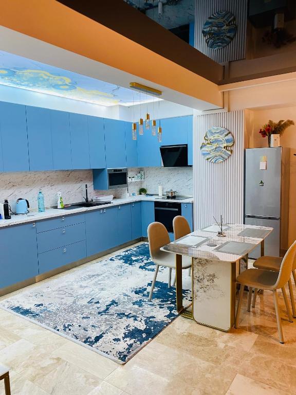 a kitchen with blue cabinets and a table and chairs at Luxury Mamaia Central in Mamaia