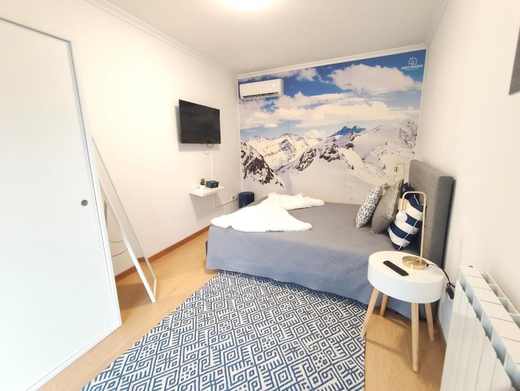 a bedroom with a bed with a painting on the wall at Casa Dos Passos in Guarda