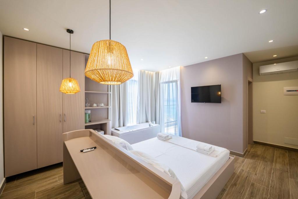 a room with a bed and a television and lights at Mirage Bay Deluxe in Sarandë