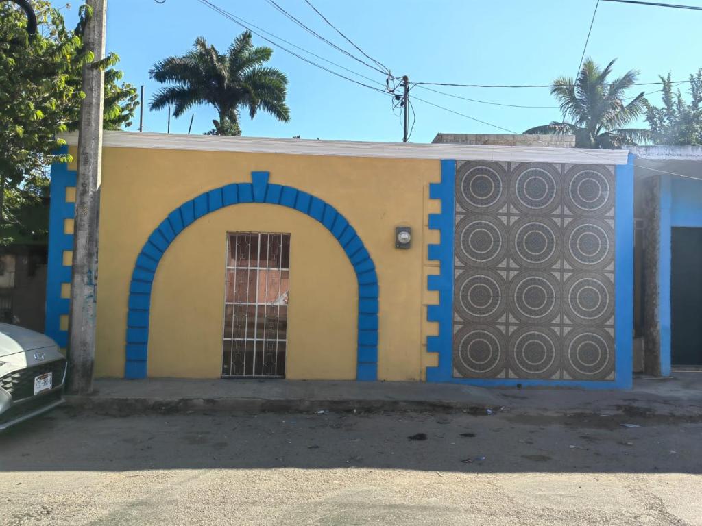 a blue and yellow building with an arch and a door at Casa Victoria in Valladolid