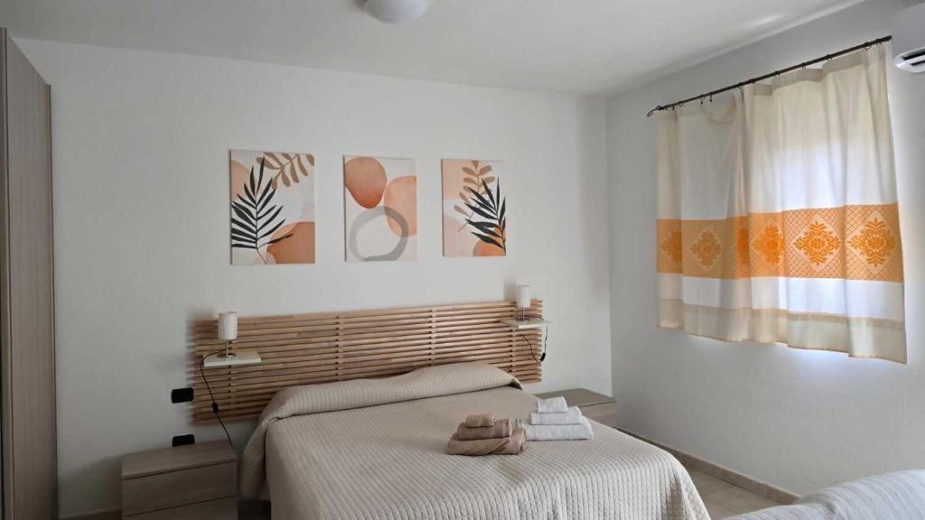 a bedroom with a bed and two paintings on the wall at Monolocale in centro con parcheggio privato! in Palau
