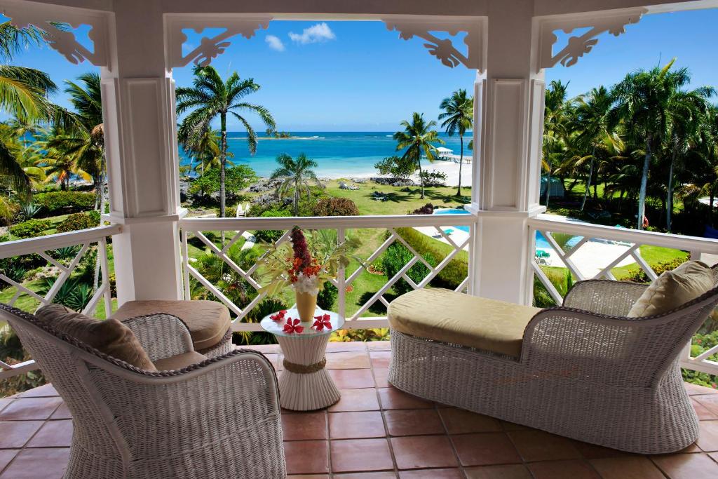 porche con sillas y vistas al océano en Hotel Villa Serena en Las Galeras
