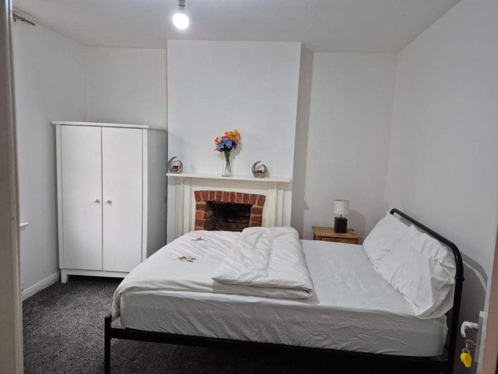 a bedroom with a bed and a fireplace at CityLink House in Aldershot
