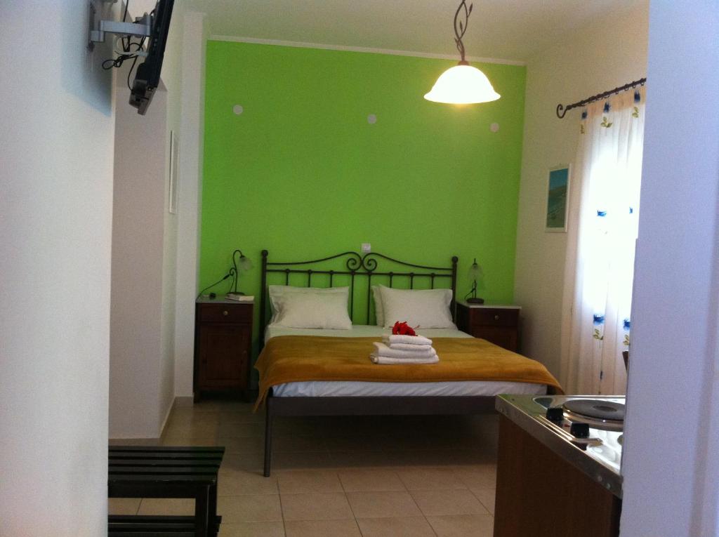a green bedroom with a bed with a green wall at Paleochora Elizabeth Apartments in Palaiochora