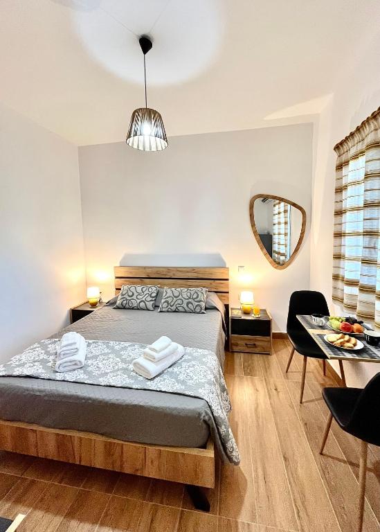 a bedroom with a bed and a table and a mirror at Elina's Rooms in Poros