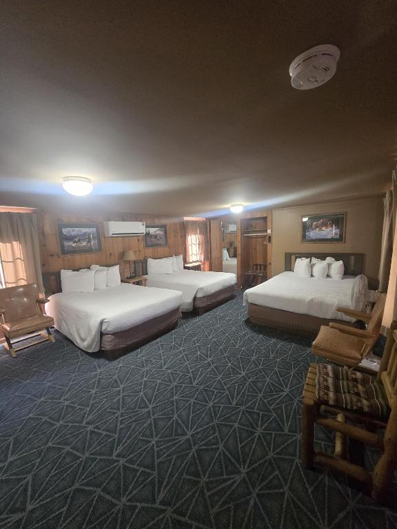 a hotel room with three beds in a room at Trails end motel in Dubois