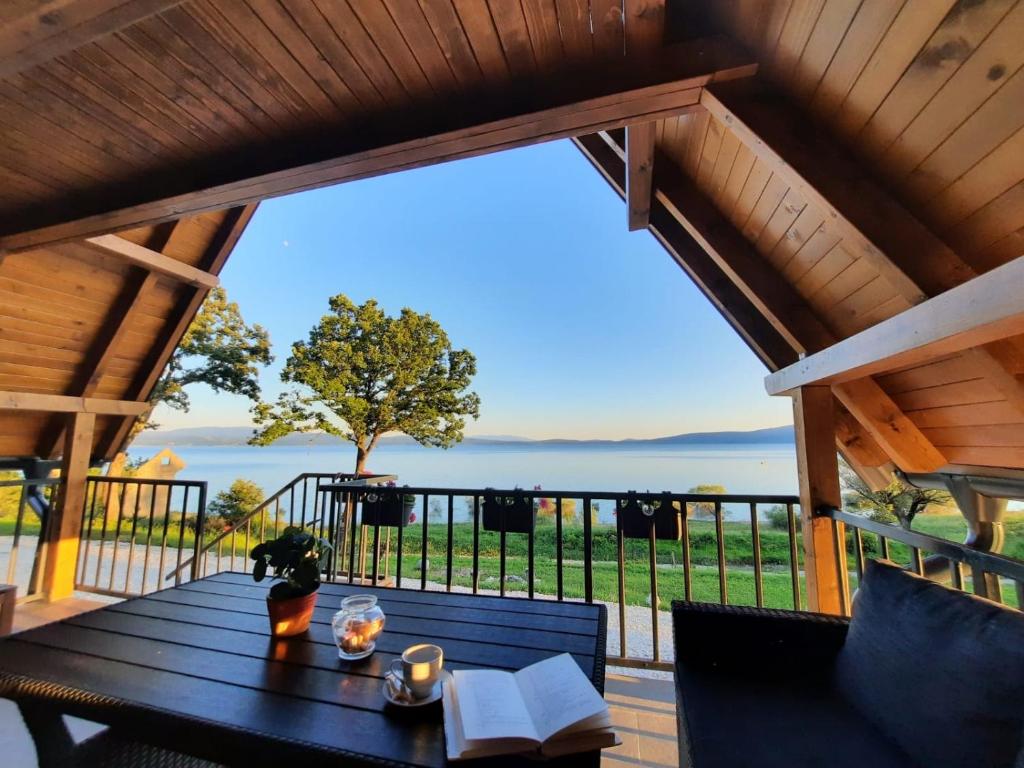 a table on a deck with a view of the water at Lake House Beliz in Livno