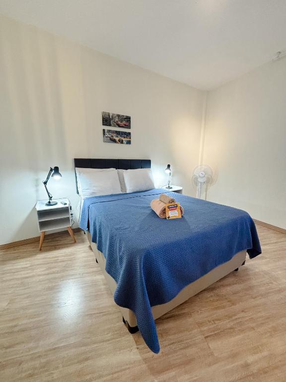 a bedroom with a large bed with a blue blanket at AP Smart Glicério in Campinas