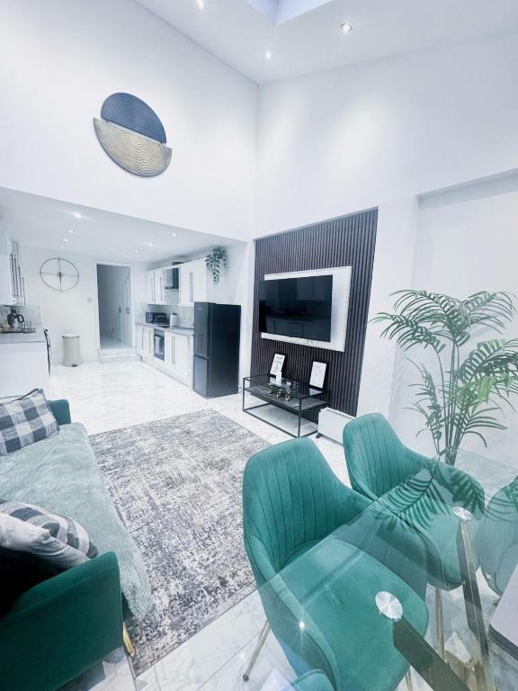 a living room with a couch and chairs and a tv at Modern Luxury 2 Bed and Private Studio Room with Parking in Catford