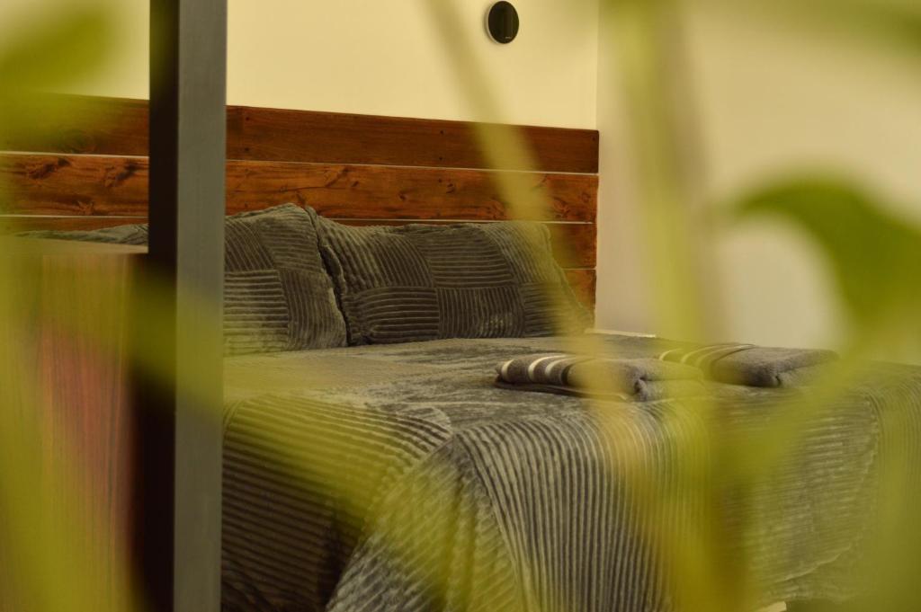 a bed with a wooden headboard in a room at Las Loicas Chalten Apart in El Chalten