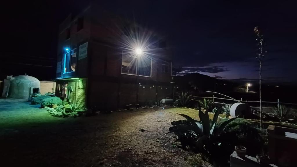 a house with a light on the side of it at night at Cuanax hotel boutique tematico - Mineral de Pozos in Mineral de Pozos