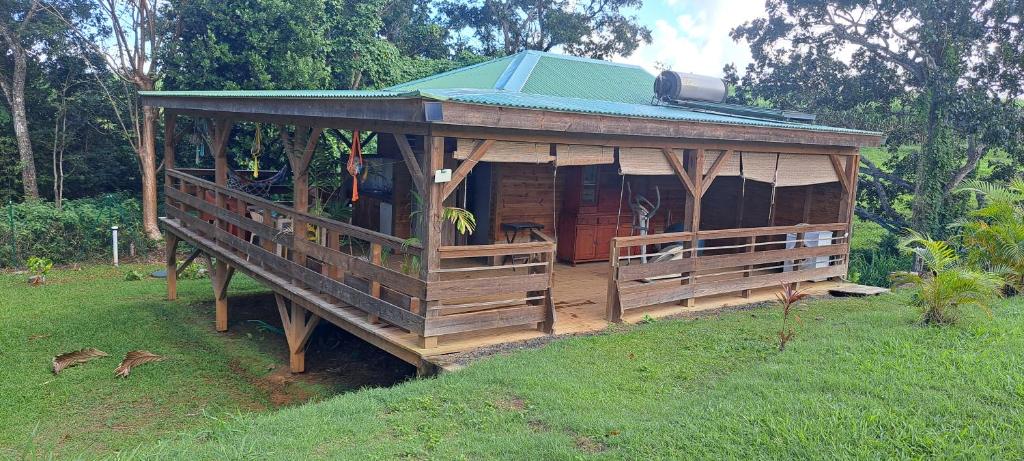 a large wooden house with a green roof at Plenitude Bungalow in Sainte-Rose