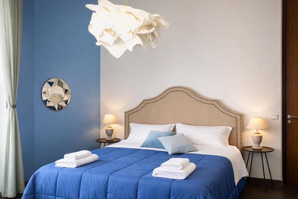 a blue bedroom with a bed with towels on it at Maison Geraldine in Marcianise