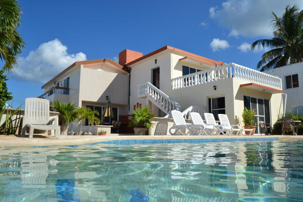a villa with a swimming pool in front of a house at Casa Sol-Oasis del Mar in Progreso