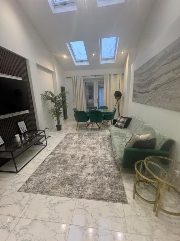 a living room with a couch and a table at Spacious Luxury 2bd with extra Private Studio Room in Catford
