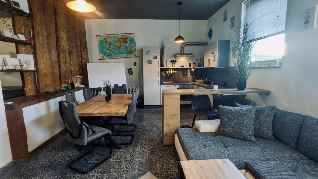 a living room with a couch and a table and a kitchen at Das Atelier - Kunstvoll verweilen in Ichtershausen