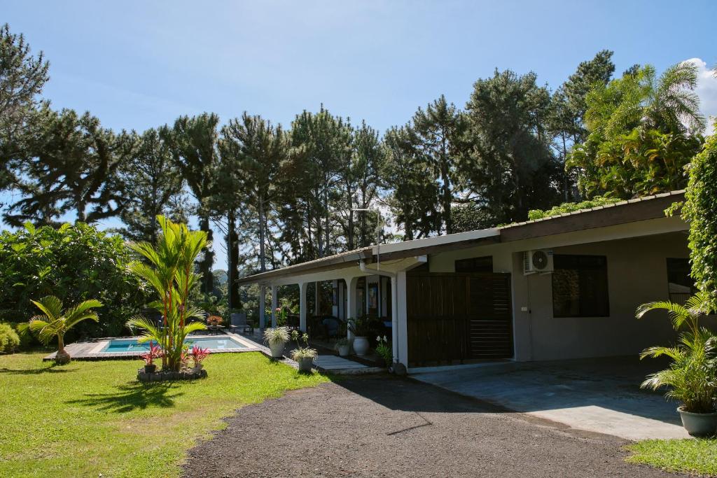 a house with a swimming pool in a yard at Enjoy Camanukea Lodge in Mahina